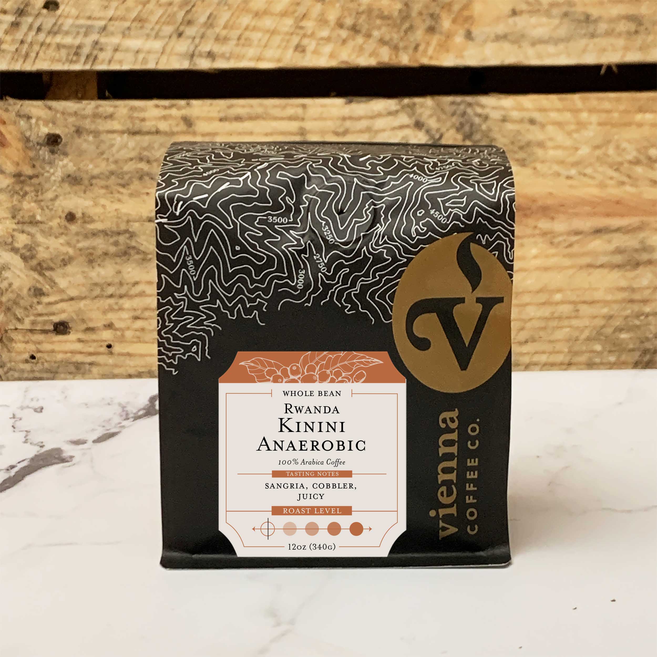 Coffee bag labeled 'Rwanda Kinini Anaerobic' from Vienna Coffee Co. on a wooden background